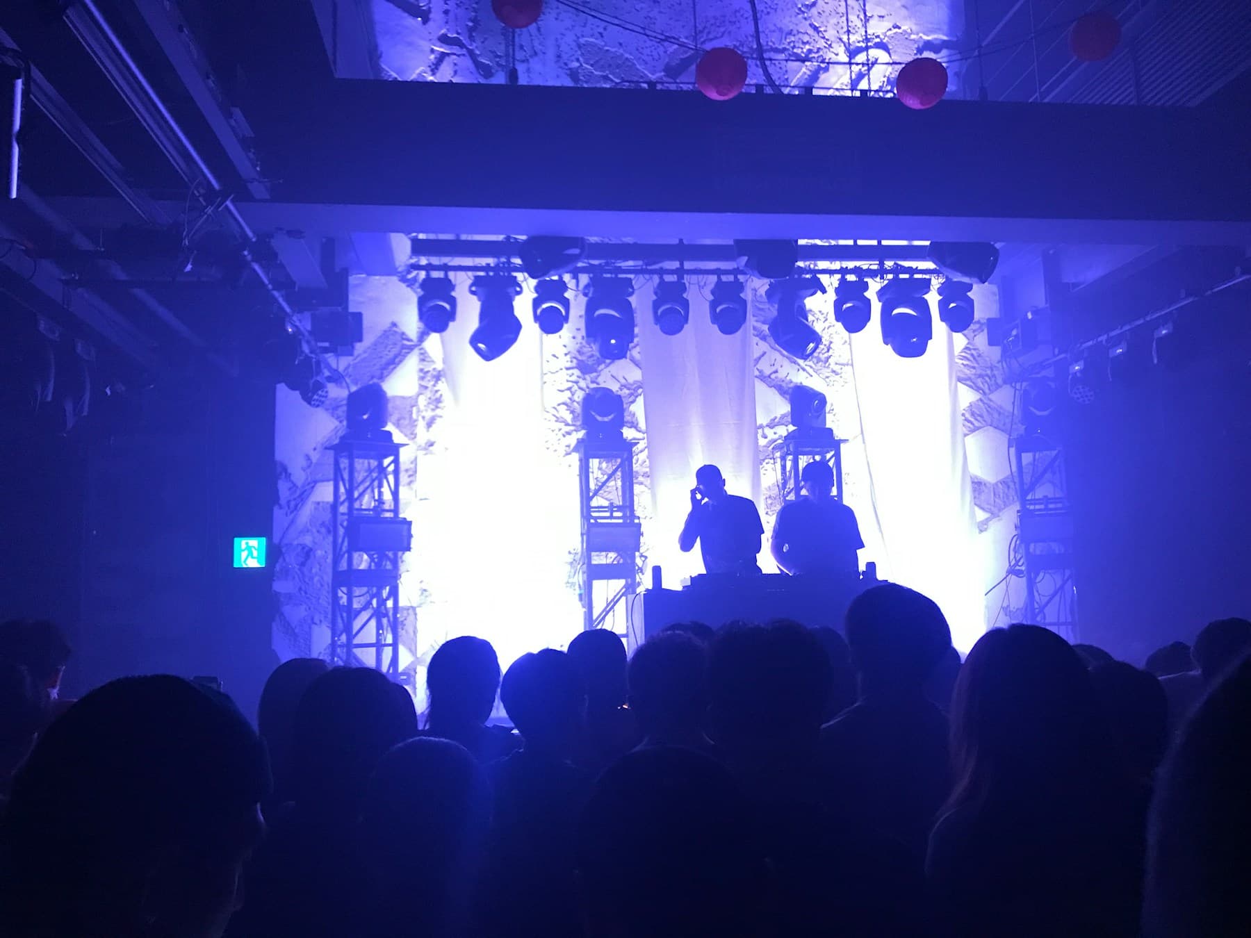 Silhouetted crowd against the light of a bar