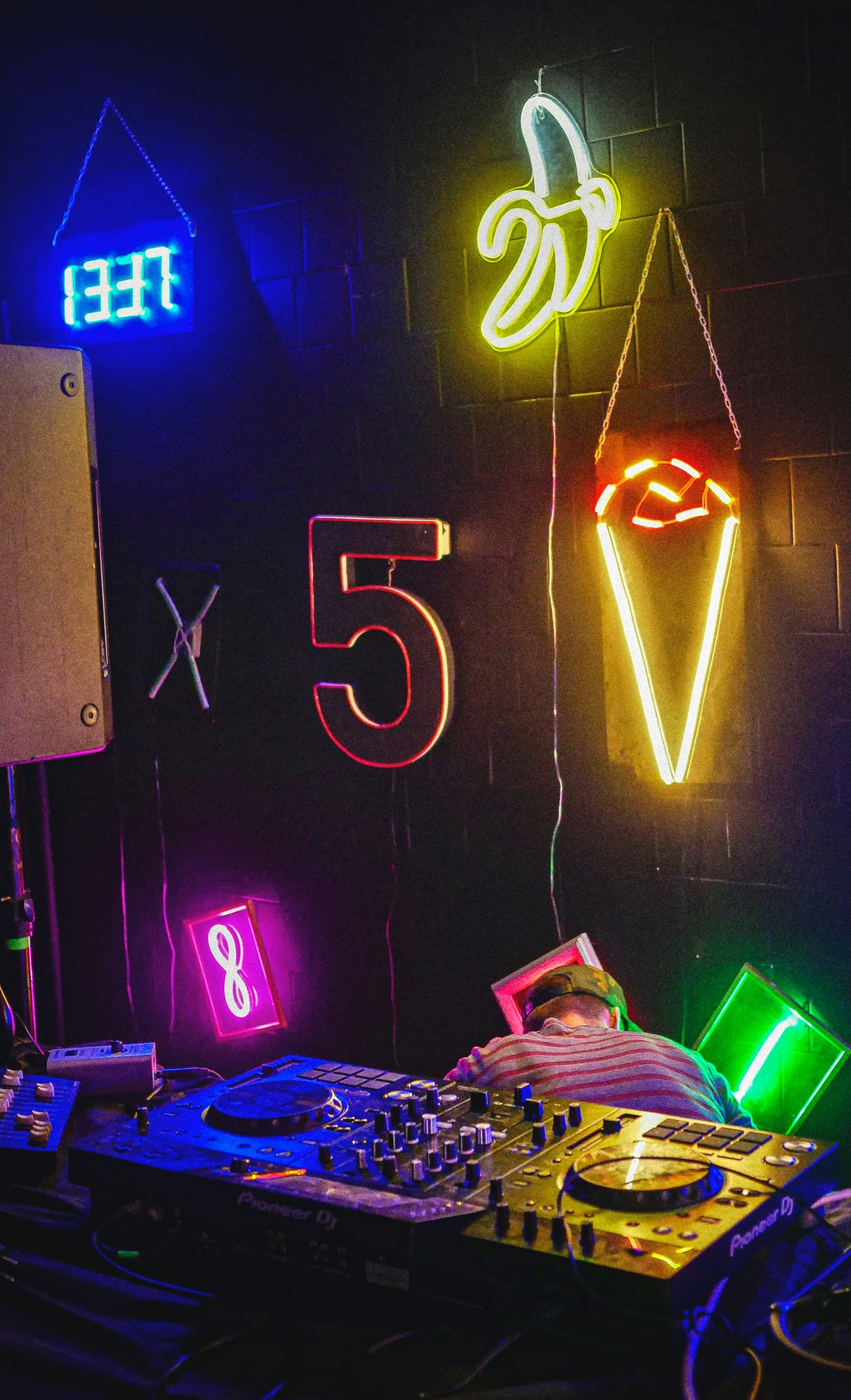 A DJ booth lit by neon signs