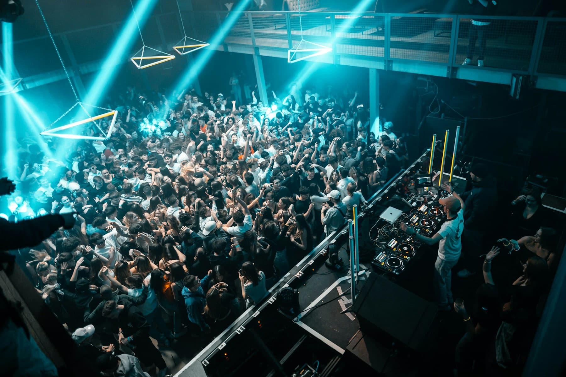 A crowd of people standing around a DJ booth
