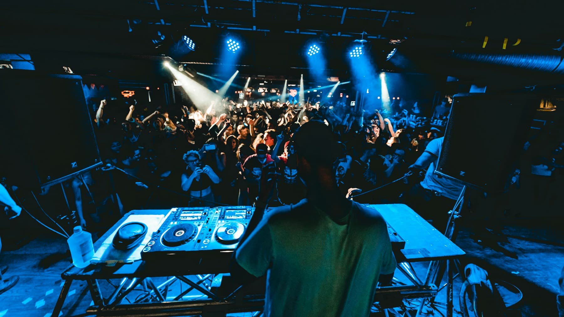 A DJ performing to a crowd at night